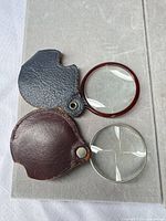 Both folding magnifiers opened to show lenses and covers
