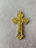 Front view of gold tone filigree cross pendant