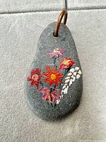 Front view of stone keychain showing floral painting and metal loop