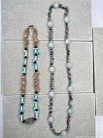 Full view of both necklaces laid flat