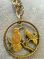 Close-up of pendant front showing bird motif and wear