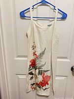 Full front view of ivory floral sundress on hanger