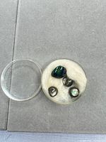 All four cabochons in storage jar with lid