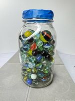 Full view of jar filled with marbles, lid visible
