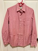 Full front view of shirt hung on hanger