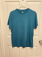 Full front view of teal J.Crew T-shirt on hanger