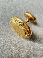 Front view of floral-bordered oval cufflink