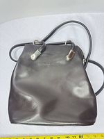 Front view of Lancaster leather bag showing handles, strap rings and overall shape