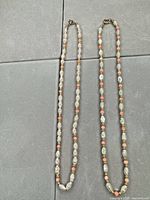 Full view of both necklaces laid flat