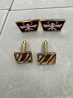 Both cufflink pairs side by side on display surface