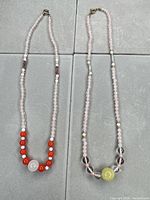 Both necklaces laid flat showing overall design and clasps