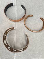 Top-down view of three copper cuff bracelets