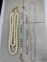 Full view of three necklaces laid flat