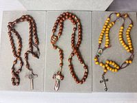 All three rosaries laid out showing beads and crucifixes