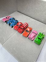 All eight die-cast cars lined up on grey background