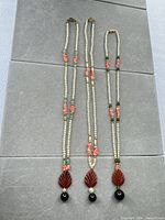 Full view of three necklaces laid flat