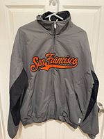 Front view of gray Majestic San Francisco Giants jacket displaying logo and overall condition