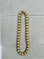 Full view of entire beaded necklace laid flat to show length and design