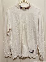 Full view of front of white long sleeve shirt with mock neck, showing overall condition