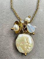 Close-up of pendant showing baroque pearl, round pearl, crystal glass bead and metal accents