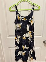 Front view of sleeveless tropical print midi dress on hanger