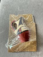 Front view of painted wood figurine wrapped on board