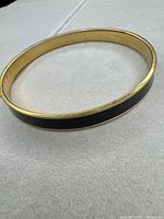 Full view of bangle showing black enamel and gold-tone edges