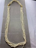 Full view of five-strand freshwater pearl rope necklace laid flat