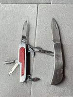Both multi-tool knives open to show blades and tools