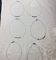 Six wire necklaces laid flat to show quantity and overall style