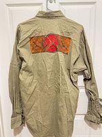 Rear view of Natives khaki canvas shirt showing back graphic