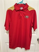 Full front view of polo shirt on hanger
