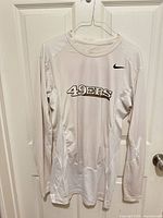 Full front view of white Nike 49ers long sleeve shirt on hanger