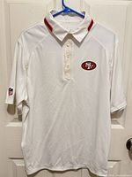 Full front view of white Nike 49ers polo on hanger