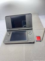 Nintendo DSi XL open with stylus and microSD adapter visible