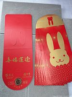 Stack of red envelopes showing rabbit design and one opened to show inside flap