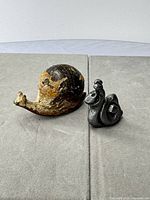 both figurines side by side on grey surface