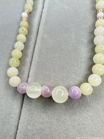 Close-up of beads showing pale green, lavender and rose gold-tone spacers