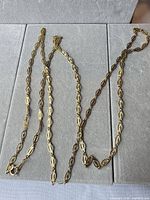 Full view of gold-tone oval link chain necklace laid flat