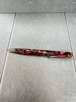 Full view of red marbled Parker mechanical pencil with gold trim