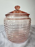 Full view of pink ribbed glass jar with lid