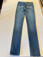 Full view of front of jeans laid flat