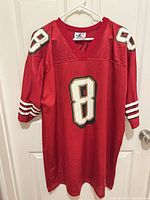Full frontal view of red #8 49ers jersey on hanger
