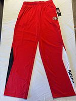 Full view of red 49ers track pants showing design and length