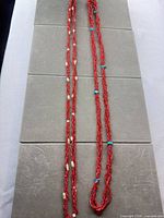Both red seed bead necklaces laid full length