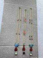 Three necklaces laid flat showing full length and pendants