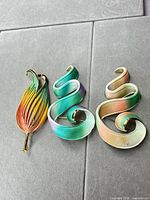 Overview of all three brooches showing shapes and colours