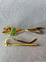 Front view of all three gold-tone tie bars showing designs