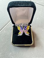 Front view of butterfly ring in box showing multicolor stones