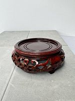 Top and side view of carved red mahogany display stand